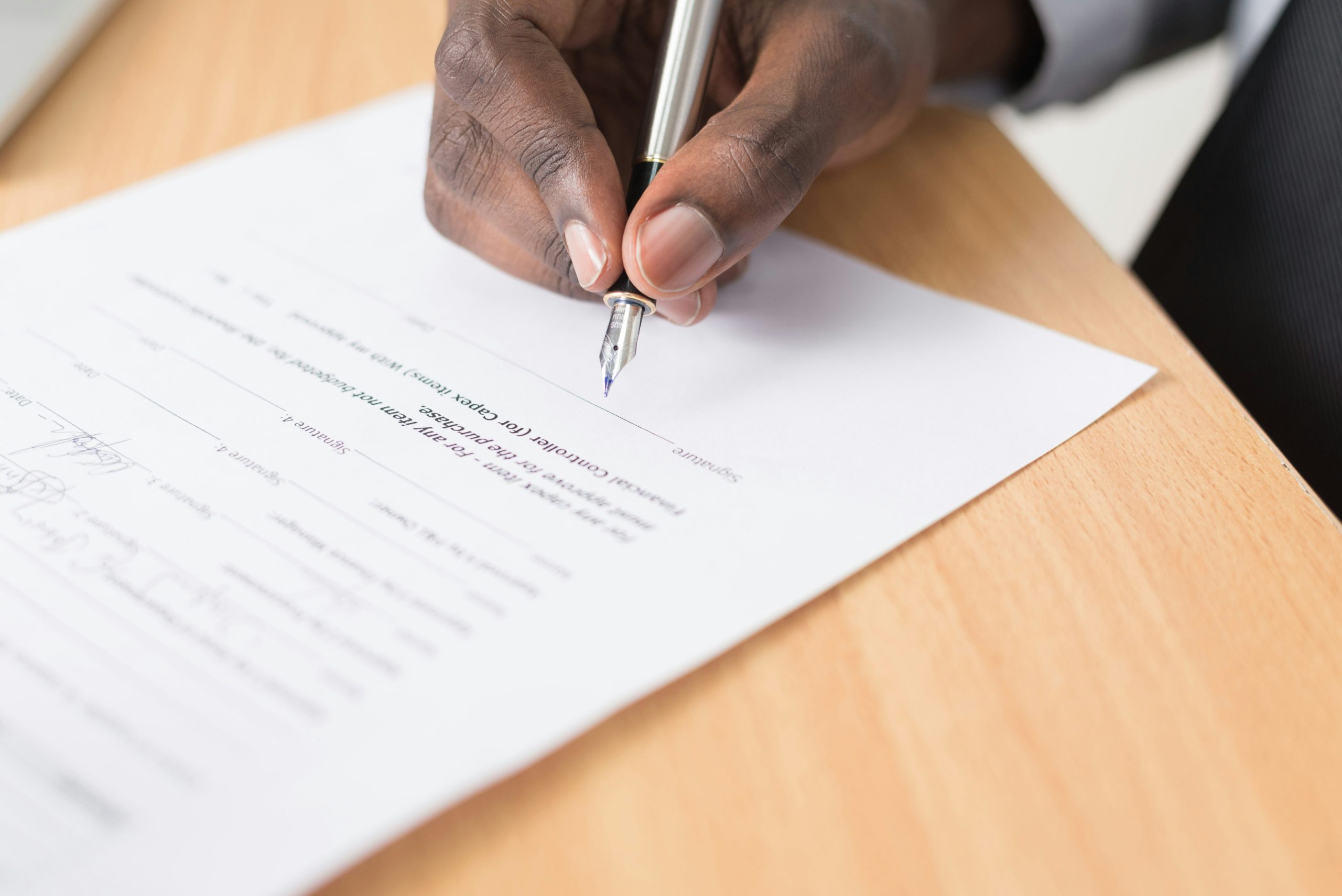close-up of a man signing an agreement